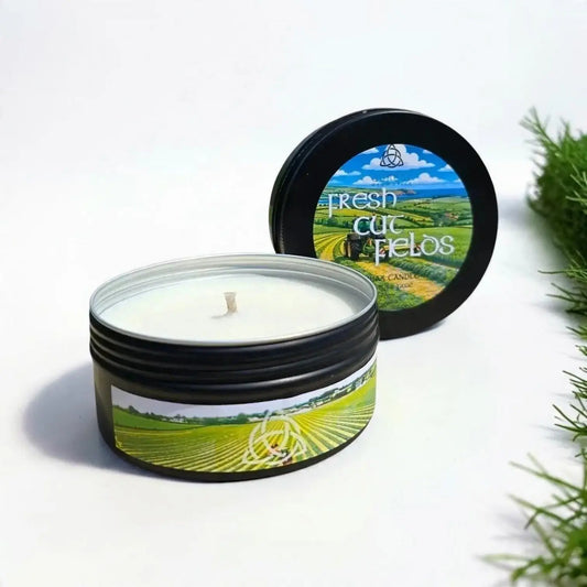 Fresh Cut Fields candle in a black tin with its lid beside it