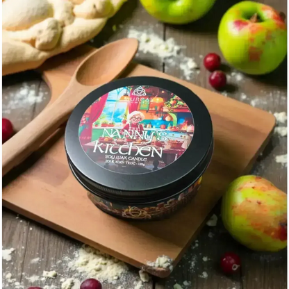 Nanny's Kitchen candle tin on a wooden board with a spoon, apples and flour