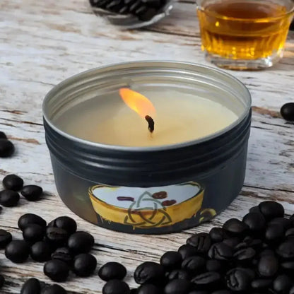 Lit Irish Coffee tin candle surrounded by coffee beans