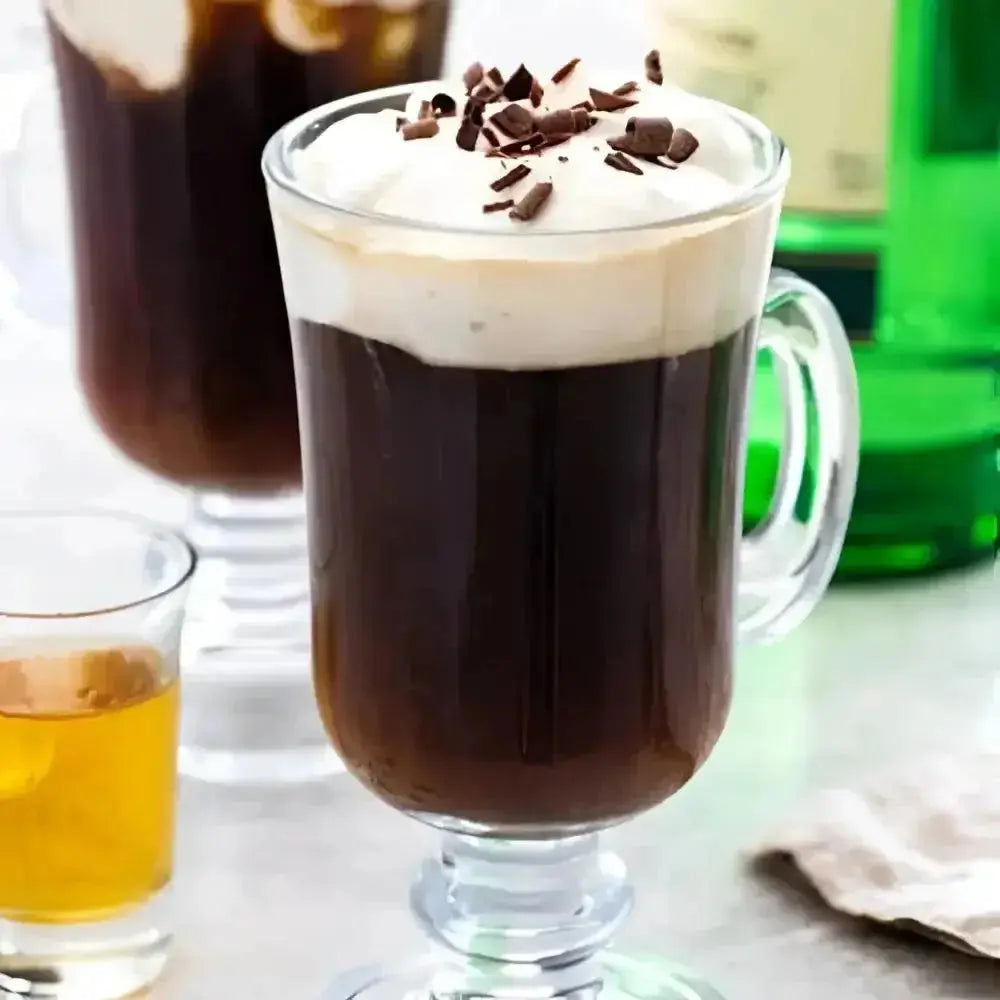 Irish coffee in a glass mug topped with cream and chocolate flakes