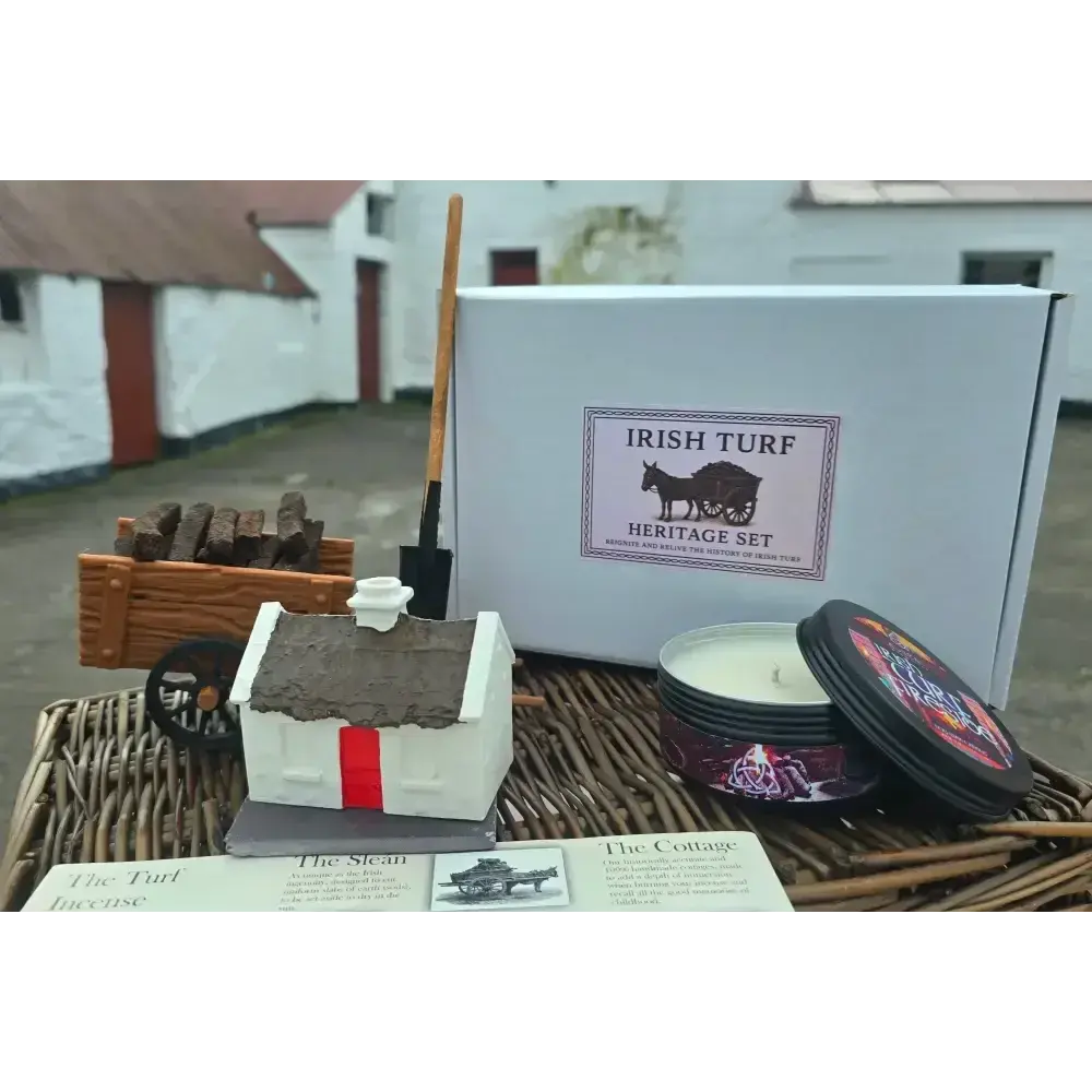 Irish Turf Heritage Set box with a cottage burner, turf cart, sleán, candle tin and info sheet on a wicker basket