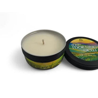 Irish Morning Dew candle in a black tin with its lid propped beside it