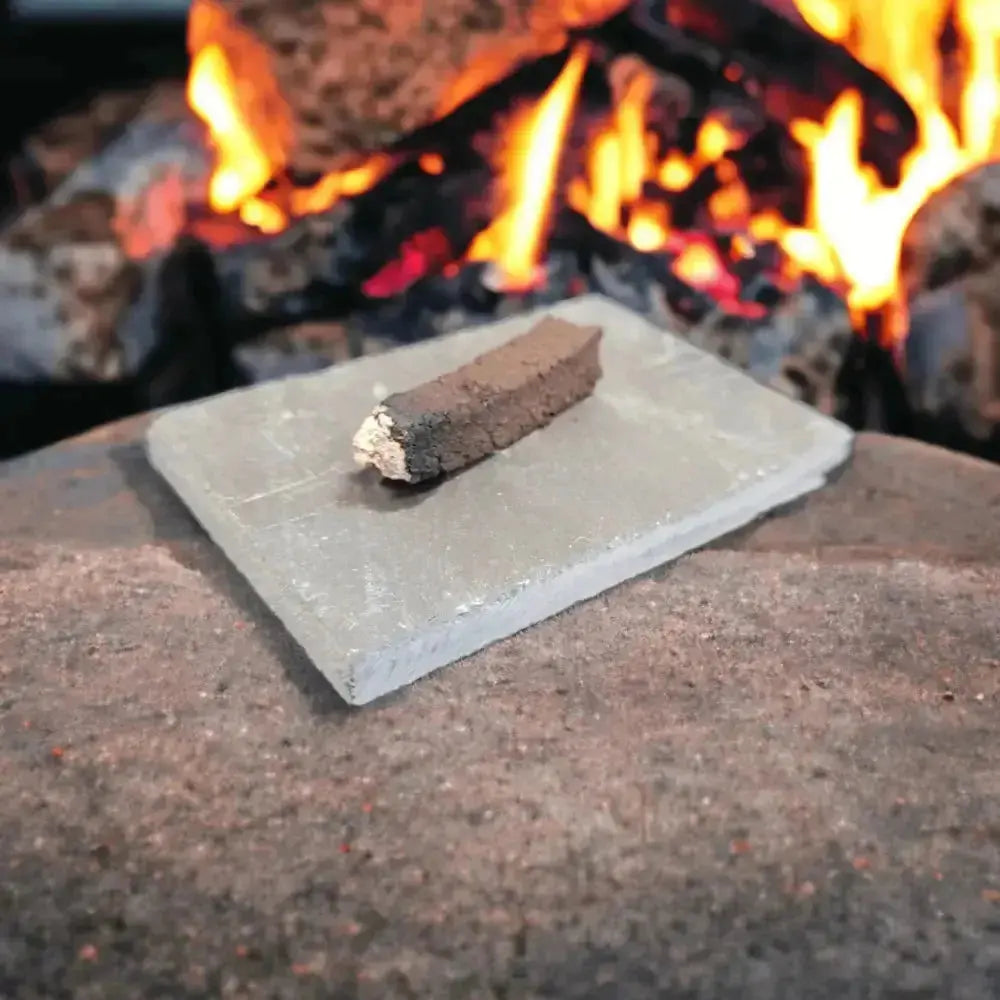 Lit turf sod on a slate in front of an open fire